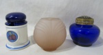 DIVERSOS - Lote contendo três peças, sendo: A) um pote para geleia em porcelana argentina vitrificada nas tonalidades azul cobalto e branca, decorado com frutos ao centro, arrematados com faixas e filetes na cor azul claro, marcado no fundo; B) um pequeno vaso floreira bojudo em vidro na cor azul, com tampa fenestrada em metal dourado; C) um vaso decorativo em vidro fosco rosa, ornamentado com lapidação de canelados. Med. maior: alt total 13 cm x diam da borda 8 cm/ menor: alt 11,5 cm x comp da borda 6 cm x larg da borda 4,5 cm.