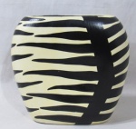 CERÂMICA - ANGELA DOBBIN - Vaso decorativo em cerâmica esmaltada nas tonalidades branca e preta, "Home Collection" ("Coleção Doméstica"), apresenta formato oval, marcado com etiqueta no fundo (conforme foto extra), medindo: alt 19 cm x comp da borda 14,5 cm x larg da borda 4,5 cm.