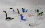MURANO - Lote contendo dez (10) esculturas em miniaturas, confeccionadas em murano, moldadas em feitios e cores diversas, sendo: uma serpente, um papagaio, um sapo e outros. Med. maior: 7,8 cm de altura/ menor: 3 cm de altura.