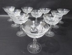 CRISTAL - Dez taças para champanhe/sobremesa em cristal europeu translucido ricamente lapidado à mão, com caneluras e sulcos , haste longa e serrilhadas apoiada sobre base circular estrelada. Seis taças com ínfimos bicados na borda. Medida 13 cm X 11,5 cm.