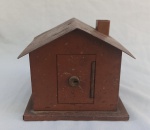 DIVERSOS, um (1) antigo cofre no formato de casa, confeccionado em chapa metálica com patina na tonalidade marrom, ligeiros sinais de oxidação e apliques de decalques, não possui a chave, medindo 14 x 14 x 12 cm, usada.