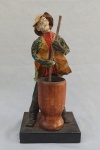 FÁBIO LOYO, uma (1) escultura representando homem socando o pilão, confeccionada em papel machê e madeira, cartão com a identificação colado na base, medindo 25 cm altura.