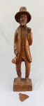 ARTE POPULAR, uma (1) escultura representando ancião de chapéu segurando uma enxada (faltando o cabo) e uma cabaça, entalhado em um bloco de madeira maciça, possui sinais de gasto e do tempo, vide fotos extra, sem assinatura, medindo 59 cm altura.