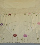 CAMA E MESA, uma (1) toalha de mesa, confeccionada em tecido de algodão na tonalidade creme, com bordado floral policromado, medindo 220 x 180 cm, acompanham 4 guardanapos na mesma padronização, medindo aproximadamente 30 x 29 cm, usada e com poucas manchas.