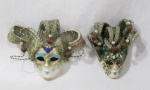 COLECIONISMO - Duas máscaras venezianas para adorno de parede, confeccionadas em faiança, pintadas à mão, ornamentadas com desenhos artesanais ricamente policromados e chapéus. Medidas: maior: alt 14 cm/ menor: 12,5 cm, aproximadamente.