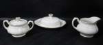 FAIANÇA - CREAMPETAL GRINDLEY ENGLAND - Uma leiteira, uma manteigueira e um açucareiro, em faiança inglesa vitrificada na cor creme, ornados com frisos na tonalidade vermelha, alças vazadas trabalhadas com folhas e volutas, pegas das tampas em forma estilizada de flor, bordas ligeiramente onduladas e filetadas à ouro, marcados no fundo. Med. maior: alt 10 cm x larg total 15 cm/ menor: alt total 7 cm x larg total 21,5 cm. Tampa da manteigueira possui um fio de cabelo.