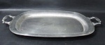 METAL PRATEADO EBERLE - Uma (1) bandeja confeccionada em metal prateado, em formato retangular, galeria central lisa e circundada por gomos em alto relevo, borda aredondada, alças vazadas com cinzel de gomos. Medidas: 59,5 cm de comprimento x 38 cm de largura