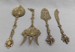 BRONZE, quatro (4) talheres ornamentais distintos, com primorosa ornamentação relevada em volutas, elementos vegetalistas, vazados, coroas, escudos, leão rampante, etc., medindo a maior peça 27 cm, vide fotos extra.