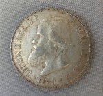 NUMISMÁTICA, Brasil, Império, uma (1) moeda, 2000 reis 1889, prata (900/916 milésimos), 3 sistema monetário, 4 tipo, 25,5gr, 37mm diâmetro, 2,7mm espessura, bordo serrilhado, 2 reinado, D. Pedro II, muito bom estado de conservação, anverso: Efígie de D. Pedro II, na orla a legenda PETRUS II D. G. C. IMP. ET PERP. BRAS. DEF. e o ano de cunhagem realizada à época na Província do Rio de Janeiro; reverso: no enxergo brasão do império na orla o dístico do valor de face e o DECRETO DE 1870, possui riscados.