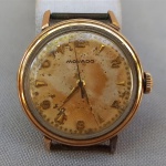 RELÓGIO, um (1) de pulso da marca MOVADO (fundada em 1881, por Achille Ditesheim, em La Chaux-de-Fonds, Suíça; em 1983 foi vendida para Assista Corporation, fundada por Gedalio Grinberg, nos EUA), mostrador com algarismos arábicos, automático, funcionando, caixa em metal dourado, medindo 32 mm diâmetro, tampa em aço, falta a pulseira.