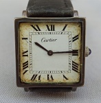 RELÓGIO, um (1) de pulso da GRIFE CARTIER (fundada em 1845 em Paris, por Louis-François Cartier, fabricante de Jóias, Relógios e objetos de luxo; tornada célebre pelo seu filho Louis Cartier; esteve sobre o comando da família até o ano de 1964; atualmente pertence a Compagnie Financière Richemont S/A), mecanismo original com 17 rubis ou safiras, a corda, parado, mostrador branco com algarismos romanos, coroa com detalhe em safira, caixa em prata contrastada 925 milésimos, medindo 26 x 26 mm, pulseira em couro, usado e sem garantia, acondicionado na caixa original.