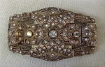 JOIA, um (1) antigo broche no padrão ART DECO, confeccionado em PRATA, com cravações em pedras brancas de tamanhos diversos lapidação antique (algumas com defeitos), medindo 75 x 45 mm, peso 27,5 gr.
