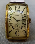 RELÓGIO, um (1) antigo de pulso da marca CYMA (fundada em 1862 pelos irmãos Joseph Schwob e Theodore Schwob na Suíça; em 1892 associaram-se a Henri Sandoz & Cie Empresa Atacadista de relógios, tornando-se CYMA WATCH Co.; atualmente é propriedade de STELUX INTERNATIONAL Ltd.), mecânico, a corda parado, com 15 rubis ou safiras, máquina numerada 558431, mostrador branco com algarismos romanos, caixa espessada a ouro (plaquê dor),  caixa com numeração interna 0124946 154569 140, medindo 45 x 27 mm, falta a pulseira, usado e sem garantia.