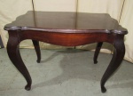 MOBILIÁRIO, uma (1) mesa de centro no padrão inglês CHIPPENDALE, confeccionada em madeira e placagem, tampo recortado com borda em degrau, saia abaulada, pés ligeiramente curvos com terminações em cachimbo, sinais de uso, medindo 45,5 x 59,5 x 39,5 cm.