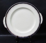 FAIANÇA - CREAMPETAL GRINDLEY ENGLAND - Um prato para bolo em faiança vitrificada na cor creme, com bordas adornadas com faixa na tonalidade azul cobalto, sobreposta com guirlandas de flores, arabescos e filetes em vasta pintura à ouro, marcado no fundo, medindo: 31 cm de diâmetro. Possui um colado na pega lateral.