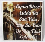 AZULEJO - Um azulejo pintado à mão com tinta mista, com figura de filhos de Ogum, com a inscrição: "Cuida Da Sua Vida. Que Da Vida Do Meu Filho Cuido Eu". Medidas: 20 x 20 cm.