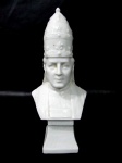 ARTE SACRA - Busto representando Papa Pio X, confeccionado em porcelana vitrificada branca, com trajes típicos, decoração com realces relevados, base rachada, conforme foto extra. Med. altura: 19 cm: base: 5,2 x 4,8 cm.
