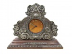 RELÓGIO ORIS - Relógio de mesa, confeccionando em jacarandá, mecanismo a corda, parte frontal e base guarnecidas com prata de lei, ricamente cinzelada com motivos vegetalistas, volutas e perolados, mostrador circular e ponteiros em metal, numerais com algarismos indo-arábicos. Med. altura: 14 cm: comprimento: 18 cm: profundidade: 5,5 cm. Máquina necessita de revisão e falta vidro de proteção do mostrador.