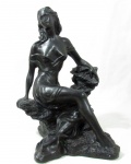 ESCULTURA - Grande escultura em estuque patinado de negro, representando figura feminina semi nua sentada sobre rocha. Medidas: altura: 38 cm: largura: 28 cm: profundidade: 28 cm.