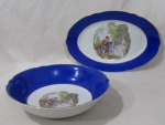 PORCELANA - REAL S. PAULO - Uma tigela e uma travessa ovalada em porcelana nacional vitrificada branca, galeria central apresentando cena galante em rica policromia, seguida de friso dourado, bordas ligeiramente onduladas e adornadas com larga faixa na tonalidade azul, finalizando com filetes em pintura à ouro, marcadas no fundo. Med. tigela: alt 6,5 cm x diam 25,8 cm/ travessa: comp 36,5 cm larg 23,5 cm. Travessa possui falhas na douração.
