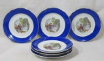 PORCELANA - REAL S. PAULO - Seis pratos para sobremesa em porcelana nacional vitrificada branca, galeria central apresentando cena galante em rica policromia, seguida de friso dourado, bordas ligeiramente onduladas e adornadas com larga faixa na tonalidade azul, finalizando com filetes em pintura à ouro, marcados no fundo, medindo: 18 cm de diâmetro. Um com mínima falha na estalagem da parte posterior da borda.