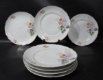 PORCELANA REAL S. PAULO - Sete pratos rasos em porcelana vitrificada branca, delicadamente decorados com motivos vegetalistas em exuberante policromia, adornados com frisos e filetes à ouro, bordas movimentadas, marcados no fundo. Medidas: 24,5 cm de diâmetro. Um com ínfimo bicado na borda.