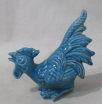 ESCULTURAS -Galo em faiança vitrificada na cor azul. Medida: 12 cm x 7 cm x 12 cm.