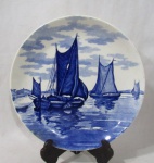 FAIANÇA - WAECKTERSBACH - GERMANY - Um prato decorativo em faiança alemã vitrificada branca, com ornamentação monocromática na tonalidade azul cobalto, apresenta cenas de barcos veleiros, marcado no fundo, medindo: 25,3 cm de diâmetro. Possui pequenas falhas na esmaltagem e fio de cabelo na borda.