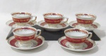 PORCELANA - REAL S. PAULO - Cinco xícaras para café com seus respectivos pires, em porcelana vitrificada branca com efeito perolizado, bordas onduladas e adornadas com largas faixas na cor vinho, sobrepostas com guirlandas de flores, folhas e filetes em pintura à ouro, alças vazadas com vasta douração, apoiadas sobre pé bolacha, marcados no fundo. Medidas: xícaras: alt 4,3 cm x diam 6,8 cm/ pires: diam 10,6 cm.