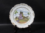 PORCELANA - REAL S. PAULO - Um prato decorativo em porcelana nacional vitrificada branca, apresentado cenários ricamente policromados intitulados como "LEMBRANÇA DO IV CENTENÁRIO DE S. PAULO - 1554 - 1954" ao centro, bordas recortadas e arrematadas com resquícios de filetes em pintura à ouro, marcado no fundo, medindo: 20 cm de diâmetro.