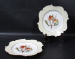 PORCELANA - LIMOGES - Elegante par de pratos decorativos em fina porcelana francesa vitrificada branca, ornamentados com frutos e folhas em rica policromia ao centro, seguido de frisos nas tonalidades preta e dourado, bordas recordadas e adornadas com largas faixas na cor creme, marcados no fundo. Medidas: 20,5 cm de diâmetro.