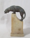 ESCULTURAS - Antigo porta relógio de bolso com escultura em petit bronze representando onça, sobre base de pedra mármore. Med. alt 18,5 cm x comp da base 8,5 cm x larg da base 6 cm. Possui bicado na base, conforme foto extra.