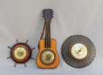 DIVERSOS, três (3) barômetros distintos para pendurar em parede, dois com suporte em madeira e um com suporte em metal, um no formato de violão;  um no formato de timão e um com gradil vazado, medindo a maior peça 25,5 cm, usados e não testados.