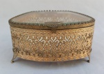 DIVERSOS, um (1) porta joias confeccionado em metal banhado a ouro, vazado em elementos vegetalistas, tampa em cristal bisotado, medindo 12,5 x 11 x 7 cm, usado, fundo no estado.