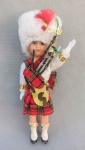 COLECIONISMO, um (01) souvenir representando boneco gaiteiro escocês com olhos móveis, medindo 16 cm de altura, usado, embalagem no estado.
