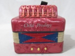 BRINQUEDOS ANTIGOS - Uma sanfona infantil, confeccionada em baquelite na cor vermelha, rajado com branco, contendo sete teclas e três botões. Altura: 11 cm: comprimento: 18 cm: profundidade: 17 cm. (não faz som).
