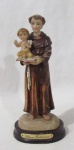 ARTE SACRA - Santo Antônio com Menino Jesus em resina policromada, apoiado sobre base em madeira. Altura total: 32 cm: base: 10 x 8 cm.