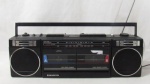 ELETRÔNICOS - Rádio portátil AM FM e toca fitas, marca Sanyo, confeccionado em baquelite na cor preta. (rádio funcionando, toca fitas não testado). Altura: 15 cm: comprimento: 50 cm: profundidade: 11 cm.