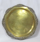 METAL - Bandeja redonda em metal espessurado a prata, borda ondulada, realçadas com flores. Medindo: 40 cm de diâmetro. (necessita de banho).