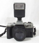 FOTOGRAFIA - Antiga câmera fotográfica para filme de rolo, com lente de 50 mm e flash acoplados, sem marca aparante. Altura: 8 x 15 cm. (não testado e sem garantia de funcionamento).