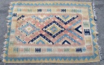 TAPETES - Um tapete kilim, persa turco, nas cores creme, vinho e cinza, decorado com motivos geométricos. Medidas: comprimento: 155 cm x largura: 107 cm. Com sinais de uso.