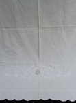 CAMA E MESA, uma (01) toalha de mesa confeccionada em Tecido de Linho na tonalidade branca, decorada com crivo e bordado floral em ponto cheio de linha branca, medindo 280 x 150cm; usada com manchas.