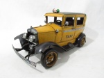 COLECIONISMO - Um modelo clássico de táxi retrô, confeccionado em lata esmaltada nas tonalidades amarela e preta. Medidas: 16 cm de altura x 34 cm de comprimento.