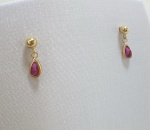 BRINCO PENDURADO COM BOLINHA CONFECCIONADO EM OURO AMARELO 18K, COM PINGENTE DE ZIRCONIA FORMATO DE GOTA VERMELHA, PESO: 0,6g, VALOR DE MERCADO: R$ 600,00