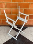 MOBILIÁRIO - Estrutura de cadeira diretor em madeira nobre, dobrável, pintada de branco. Med. 88x37x37 cm. Marcas do tempo e sem o tecido do encosto e assento.