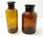 COLECIONISMO - Lote de 2 antigos frascos de farmácia em demi cristal na tonalidade âmbar. Bicados. Med. 21 cm e 20 cm.