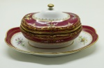 SEVRÉS PORCELANA - Parte de jogo de jantar em fina porcelana com faixa larga, pintado ao centro com motivos florais, rios detalhes dourados, assinado I Fontaine. Composto de: molheira com presentoir fixo. Med. 10x24x16 cm.