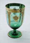 COLECIONISMO - Bela taça de coleção em demi cristal, no padrão veneziano. Corpo em tom verde e realçado em tom dourrado com aplicação de flores em relevo, pintados a mão. Alt. 12 cm.