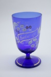 COLECIONISMO - Bela taça de coleção em demi cristal, no padrão veneziano. Corpo em tom azul e realçado em tom dourrado com aplicação de flores em relevo, pintados a mão. Alt. 13 cm. Bolhas.