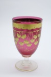 COLECIONISMO - Bela taça de coleção em demi cristal, no padrão veneziano. Corpo em tom vermelho e realçado em tom dourrado com aplicação de flores em relevo, pintados a mão. Alt. 12,5 cm. Leves bicados.